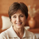 Portrait of a smiling middle-aged woman with short brown hair, looking at the viewer, conveying trust and happiness.